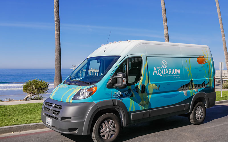 The Aquarium Express van painted with an underwater scene is parking front of La Jolla Shores.