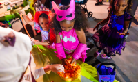 costumed guests collect candy at a trick or treat station at Birch Aquarium