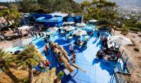 An overhead view of Blue Beach at Birch Aquarium shows people attending Indigenous Ocean Day 2024 including a tule boat building station