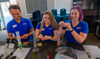 Three Birch Aquarium Educators wearing blue shirts demonstrate a Science Bites lesson 