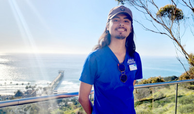 volunteer stands at railing overlooking Scripps Pier