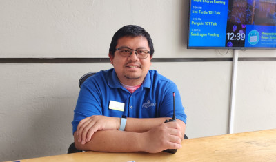 volunteer sits at information desk at Birch Aquarium